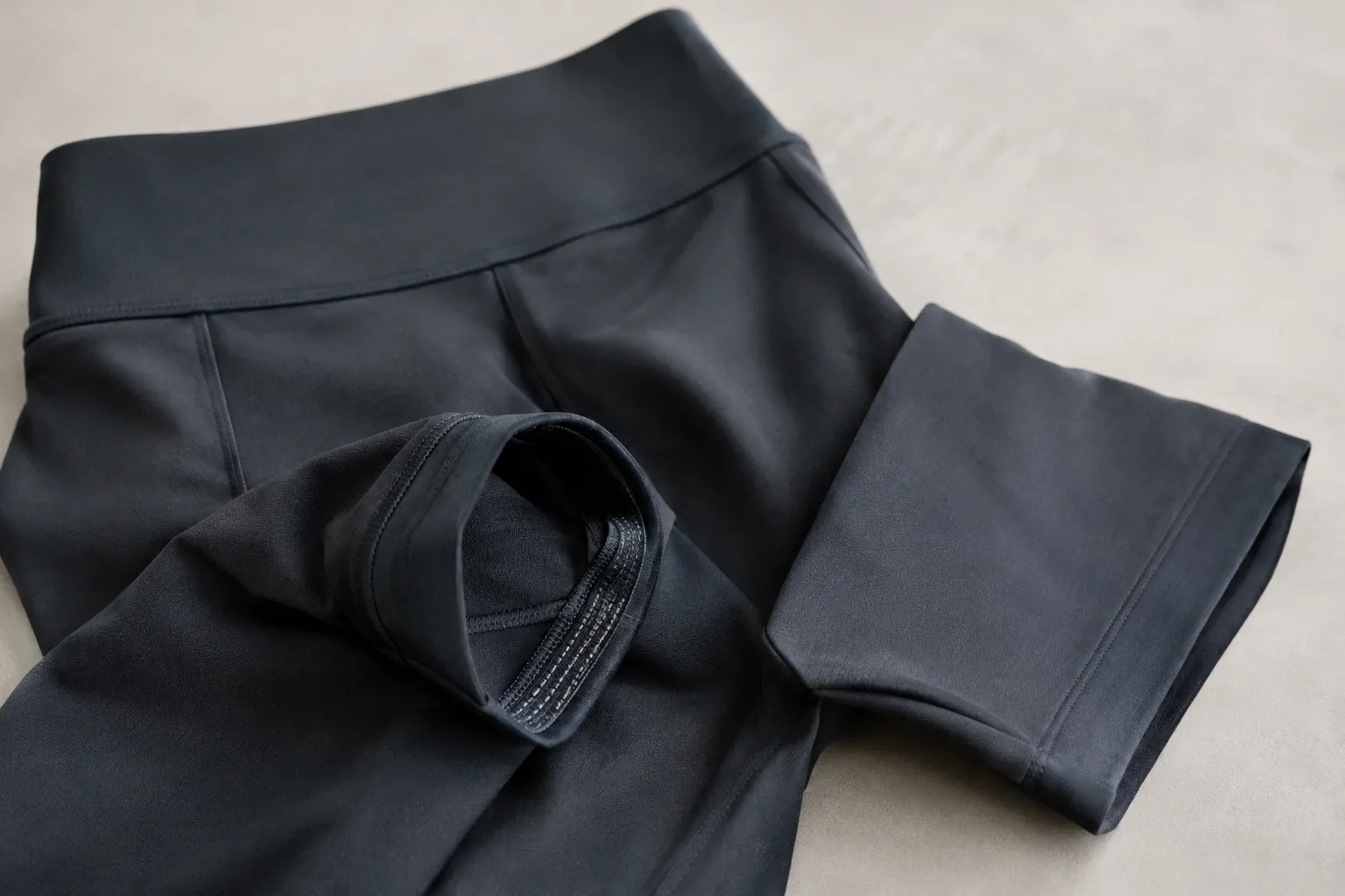 Donkere kleding met een brede tailleband, een vlakke beenrand en een omgeslagen rand met gripstroken aan de binnenzijde